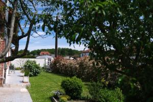 einen Garten mit Büschen und Bäumen und ein Haus in der Unterkunft La Maison De Maria in Folembray