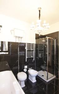 a bathroom with a toilet and a sink and a chandelier at AN Deluxe Suites in Ancona