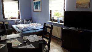 a living room with a television and a table and a couch at Ferienwohnung Putbus in Putbus