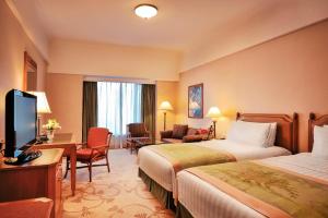 pokój hotelowy z 2 łóżkami i telewizorem z płaskim ekranem w obiekcie Shangri-La Beihai w mieście Beihai