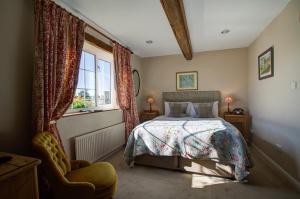a bedroom with a bed and a window and a chair at The Moonraker Hotel in Bradford on Avon