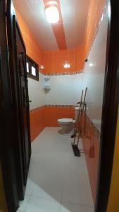 an orange bathroom with a toilet and a sink at TOP Appartement in Aourir