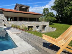 a wooden bench sitting on a deck next to a house at La villa M Évian in Publier