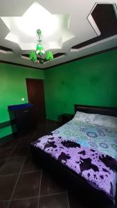 a bedroom with a green wall and a bed at TOP Appartement in Aourir