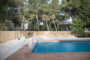 a swimming pool in a backyard with a wooden fence at Quinta la Sal in Jávea