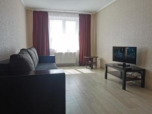 a living room with a couch and a television at Kakadu apartments in Sumy