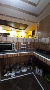 a kitchen with a counter with plates and a microwave at TOP Appartement in Aourir