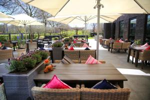 een restaurant met tafels, stoelen en parasols bij Van der Valk Hotel Rotterdam - Blijdorp in Rotterdam