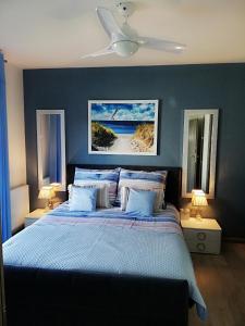 シャノジェンティにあるApartamenty Relaks & Spa Pięć Mórzのベッドルーム1室(青い壁のベッド1台、ランプ2つ付)