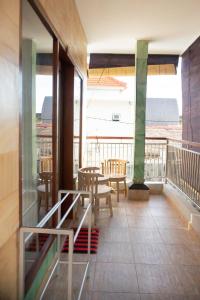 Cette chambre dispose d'un balcon avec une table et des chaises. dans l'établissement Ika Homestay, à Canggu