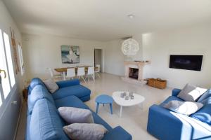 a living room with a blue couch and a table at Villa La Buena Vida in Benissa