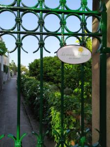 Una puerta metálica verde con un cartel. en La casa di Armando, en Capri