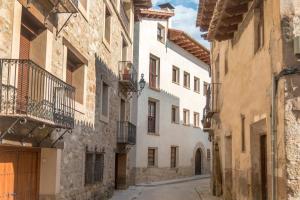un callejón en un casco antiguo con edificios blancos en CASA RURAL ADUANA, en Rubielos de Mora