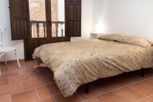 a bedroom with a bed in a room with a table at CASA RURAL ADUANA in Rubielos de Mora