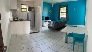 uma cozinha com paredes azuis e uma mesa e cadeiras em Condomio Coqueiros Residence em Salvador