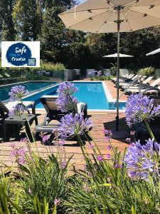 a swimming pool with purple flowers and an umbrella at Rooms Oasis Life in Split