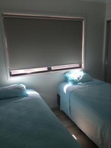 a room with two beds and a window in it at Share Rainbow Denny's House in Rainbow Beach