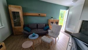 a living room with a couch and chairs and a table at Seenadel in Gelbensande