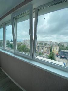 a row of windows in a room with a view of a city at Квартира с раздельными комнатами, левый берег, пр Правды, Ул Калиновая in Dnipro