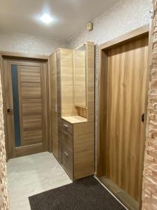 a walk in closet with wooden cabinets and a door at Квартира с раздельными комнатами, левый берег, пр Правды, Ул Калиновая in Dnipro