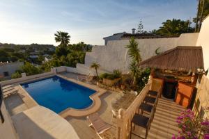 a swimming pool on the side of a house at Villa La Buena Vida in Benissa