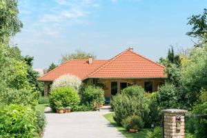a house with an orange tile roof at Toldi68 Apartmanház in Keszthely