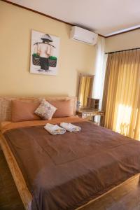 a bedroom with a large bed with two towels on it at Ika Homestay in Canggu