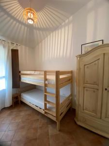 Cette chambre comprend 2 lits superposés et une armoire. dans l'établissement Casa Luisa IUN Q3032 Appartamento a 5 minuti in macchina dal Mare, à Bari Sardo