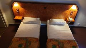 サン・フロランにあるHotel Madame Mereのホテルルーム ベッド2台 鏡付