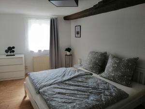 Schlafzimmer mit einem Bett und einem Fenster in der Unterkunft Ferienwohnung Benz in Klingenmünster