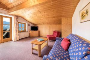 - un salon avec un canapé bleu et une table dans l'établissement Baumgartnerhof Appartment Holunder, à Lagundo