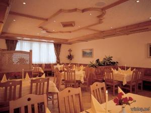 um restaurante com mesas e cadeiras brancas e um tecto em Hotel Landgasthof Hacker em Zachenberg
