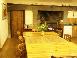a dining room with a wooden table and a fireplace at Temple Farm House in Aysgarth