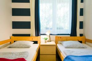 two beds in a room with a window at Toldi68 Apartmanház in Keszthely