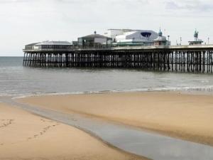 a beach with a pier in the water and a pier at The Pembroke in Blackpool +3 photos