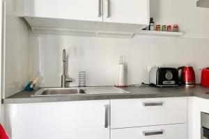 a white kitchen with a sink and a microwave at 100 Grenoble #BT in Grenoble