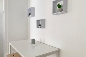 a white bathroom with a white table and a plant at 100 Grenoble #BT in Grenoble