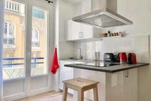 a kitchen with a black counter top and a window at 100 Grenoble #BT in Grenoble