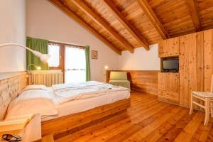 a bedroom with a large bed in a room with wooden floors at Chalet Casa Al Campo in Giustino