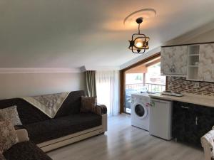 a living room with a couch and a washing machine at Karenes KUZEY Pansıyon in Çaykara