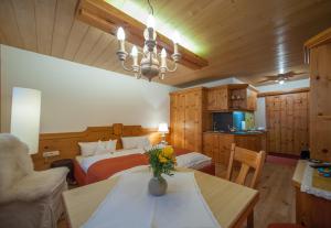 een slaapkamer met 2 bedden en een tafel met bloemen erop bij Arlsuites in Sankt Anton am Arlberg