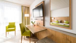 a hotel room with a desk and a bed at OHO Rooms Geisingen - Digital Access Only in Geisingen