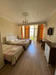 a hotel room with two beds and a desk at Hotel Eurasia in Batumi