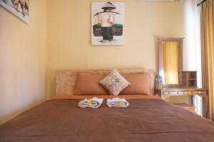 ein Schlafzimmer mit einem Bett mit zwei Handtüchern darauf in der Unterkunft Ika Homestay in Canggu