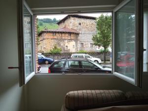 una ventana en una habitación con vistas a un coche en UGARTEKO ETXEA en Llodio