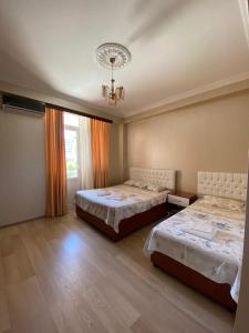 a large room with two beds and a window at Hotel Eurasia in Batumi