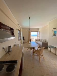 eine Küche und ein Wohnzimmer mit einem Tisch und einem Sofa in der Unterkunft Amazones Village Suites in Hersonissos