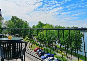 balcón con mesa y vistas al agua en WIDOKOWO Apartamenty, en Ełk