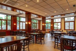 a restaurant with tables and chairs and windows at Hotel Boltaña Ordesa in Boltaña