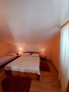 a bedroom with a bed and two lamps on two tables at Apartments and Rooms Jasna in Hvar